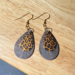 This is a pair of handmade leopard print dangle earrings.